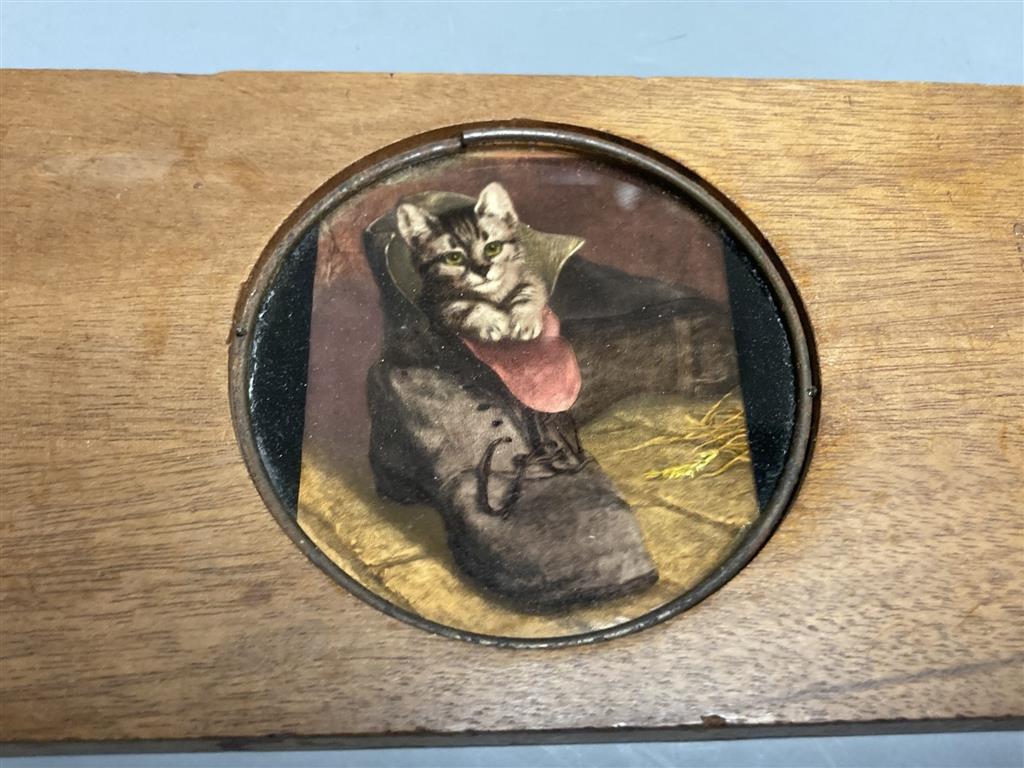 An early 20th century leather decorated easter egg, a pair of 19th century miniature ladies boots and a magic lantern Puss in Boots